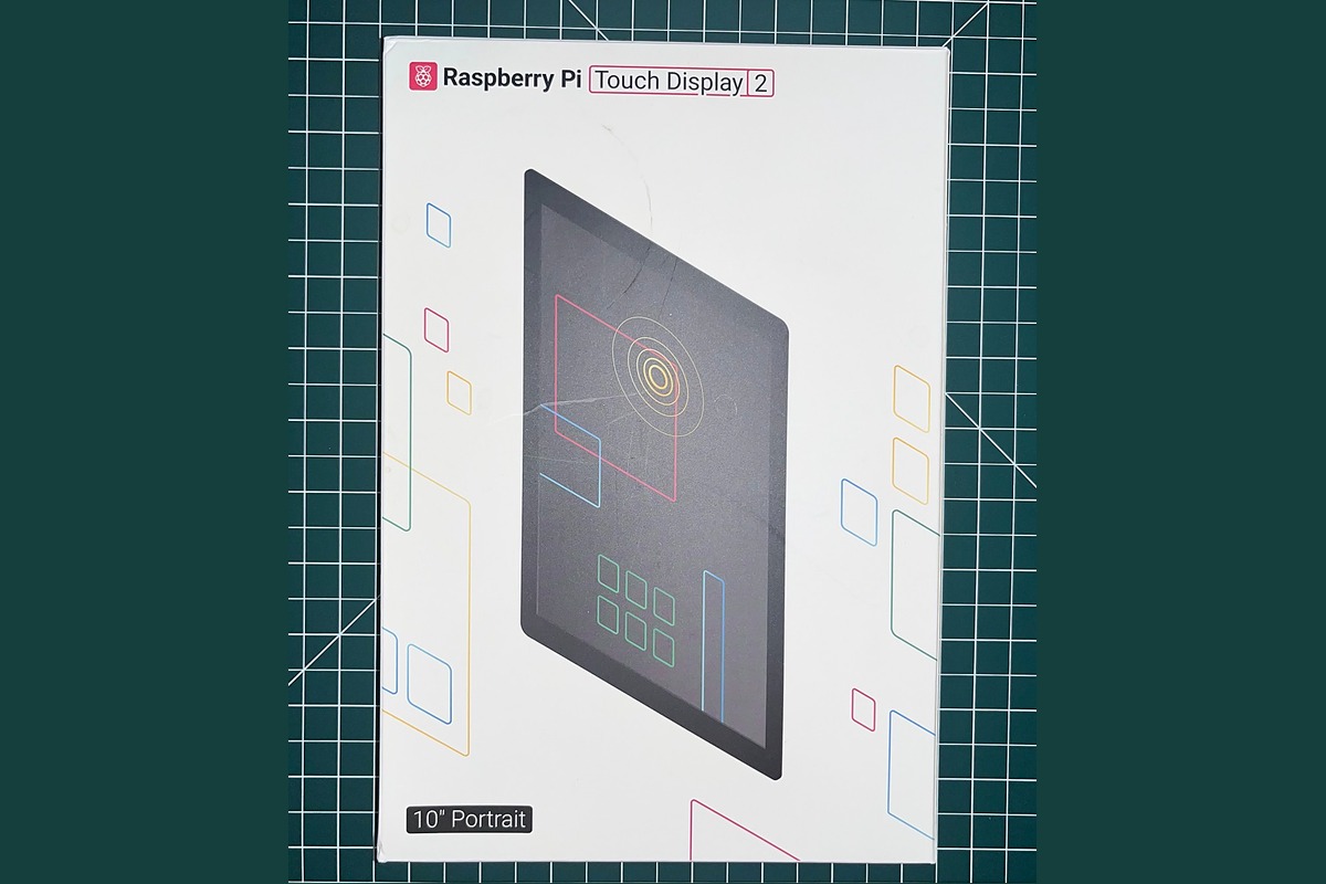 Raspberry Pi Touch Display 2 retail box on a cutting mat
